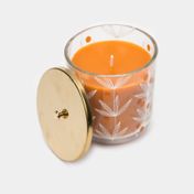 Frasco de vidrio con vela naranja